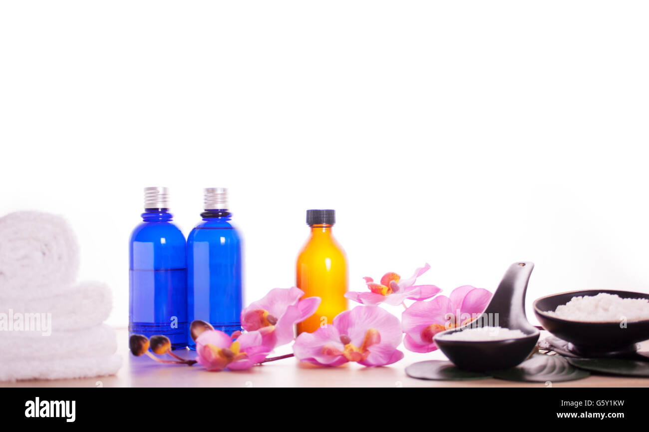 Entspannung Bad Zeit Schönheit Produktsets. Massage-Öl, Meer Salz und weißen Handtuch auf dem Holz Tisch isoliert auf weißem Hintergrund. Stockfoto