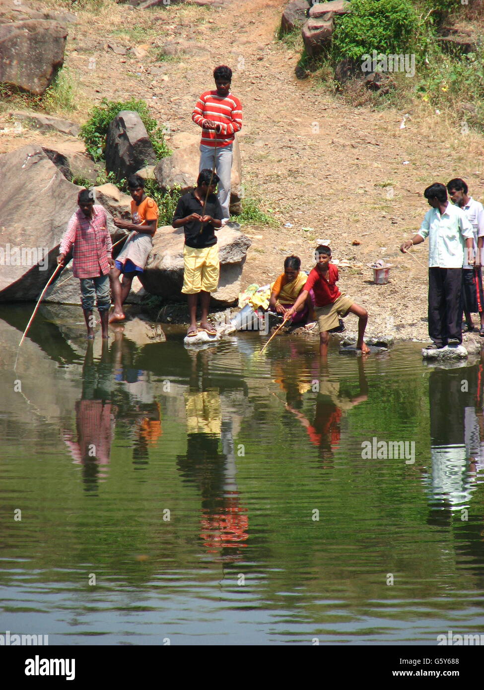 Arme Menschen fangen Fische in einem Teich in Indien Stockfotografie