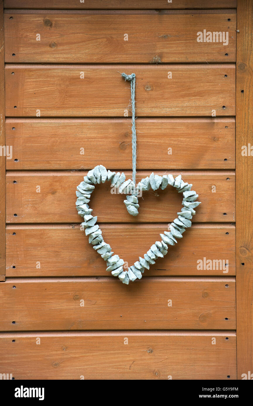 Stein Herz hängt an einem Gartenhaus. Cotswolds, England Stockfoto