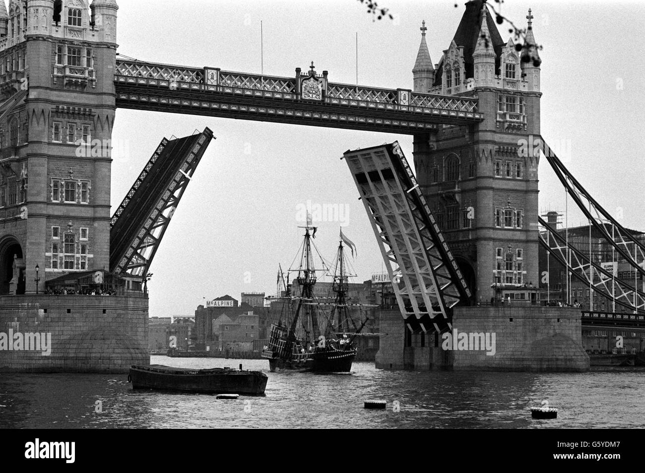 Die Golden Hinde Replik von Sir Francis Drakes elisabethanischen Schiff, das im 16. Jahrhundert die Welt umrundete, geht unter der erhöhten Tower Bridge auf der Themse in London auf ihrem Weg zum Liegeplatz am Tower Pier, wo sie für die Öffentlichkeit zugänglich sein wird. Die viereckige Segelgaleone hat eine bunte Geschichte von sich, nachdem sie die gleiche Reise etwa vierhundert Jahre später, als sie England im Jahr 1974 auf der sechs Jahre Reise verlassen abgeschlossen. Stockfoto