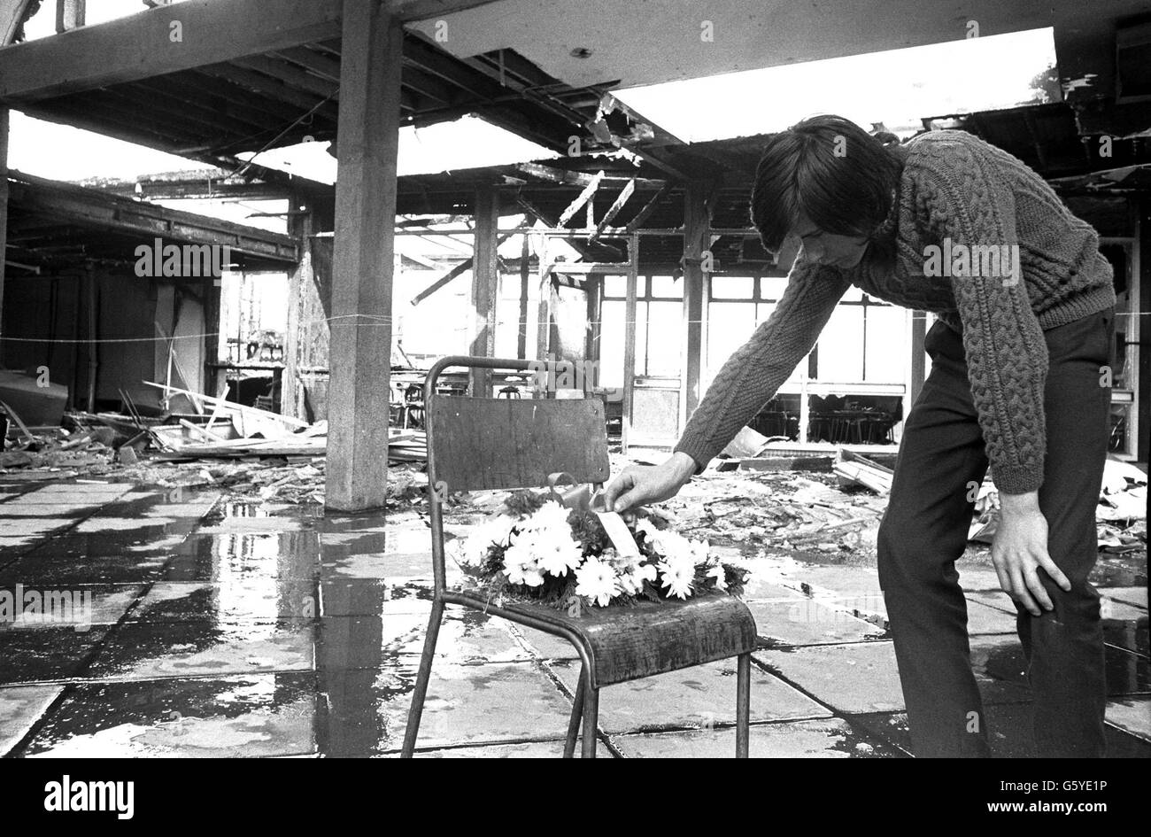 Norman Hogg, 18, untersucht einen Kranz, der auf einem Stuhl im Busbahnhof Oxford Street platziert wurde, der beim Bombenblitz "Bloody Friday" in Belfast verwüstet wurde. Normans drei Kollegen im Paketbüro gehörten zu den Toten. *16/07/02 die IRA hat sich bei allen nicht-Kämpfern entschuldigt, die während 30 Jahren Gewalt getötet wurden, Dienstag, 16. Juli 2002. Stockfoto