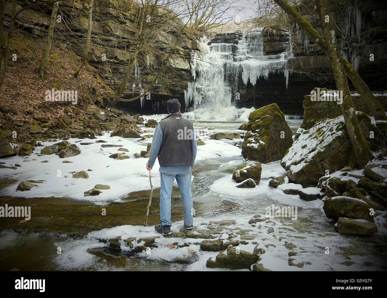 Bob Ripley, 62, aus Richmond schaut sich die Eiszapfen an, als der Bow Lee Beck in der Gibsons Cave in Teesdale im März ungewöhnlich friert, nachdem die Temperaturen gestern Abend auf minus sieben gesunken waren. Stockfoto