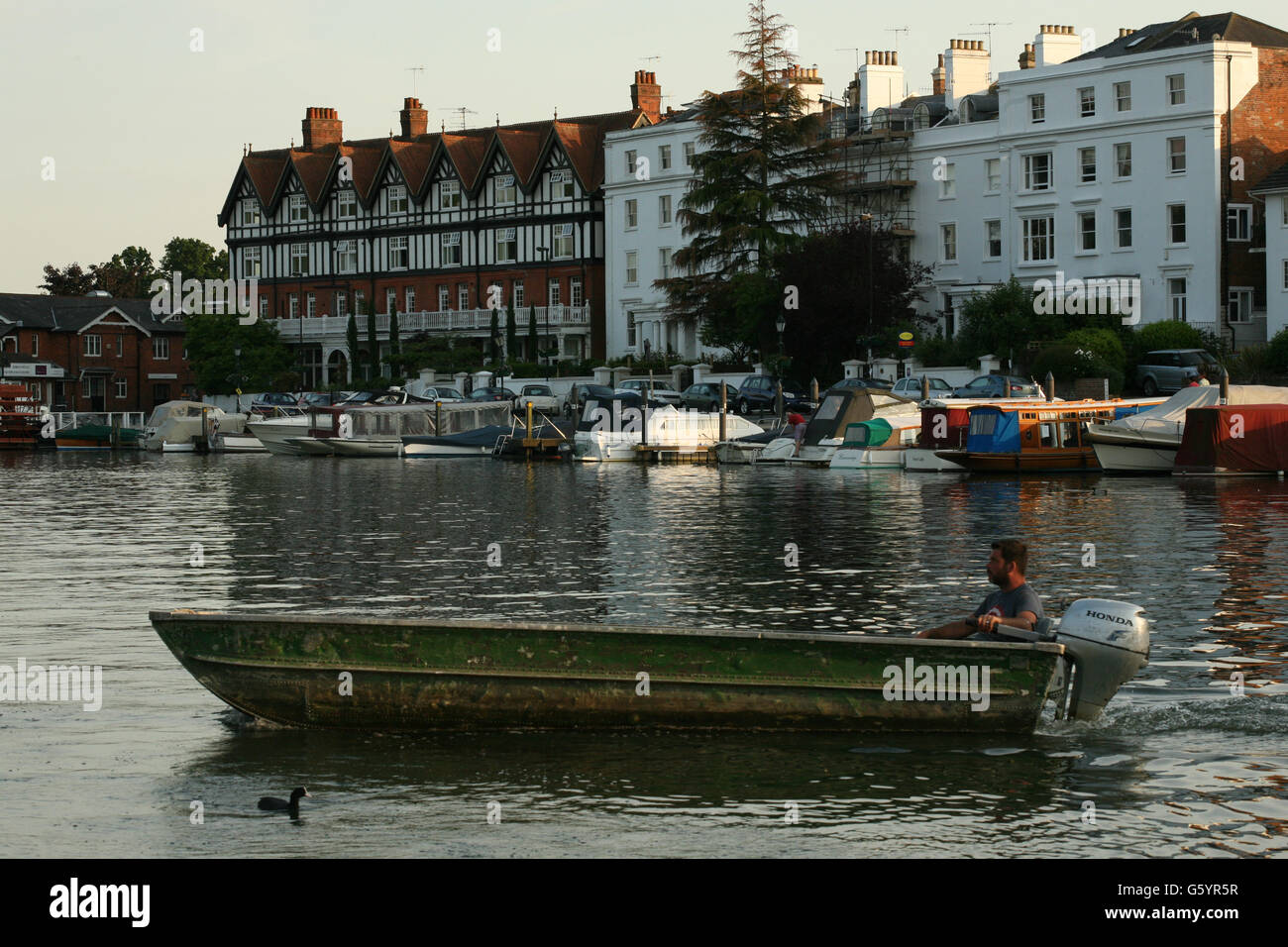 Mann im angeschlagenen altes Boot, die Überquerung des Flusses in Henley on Thames Stockfoto