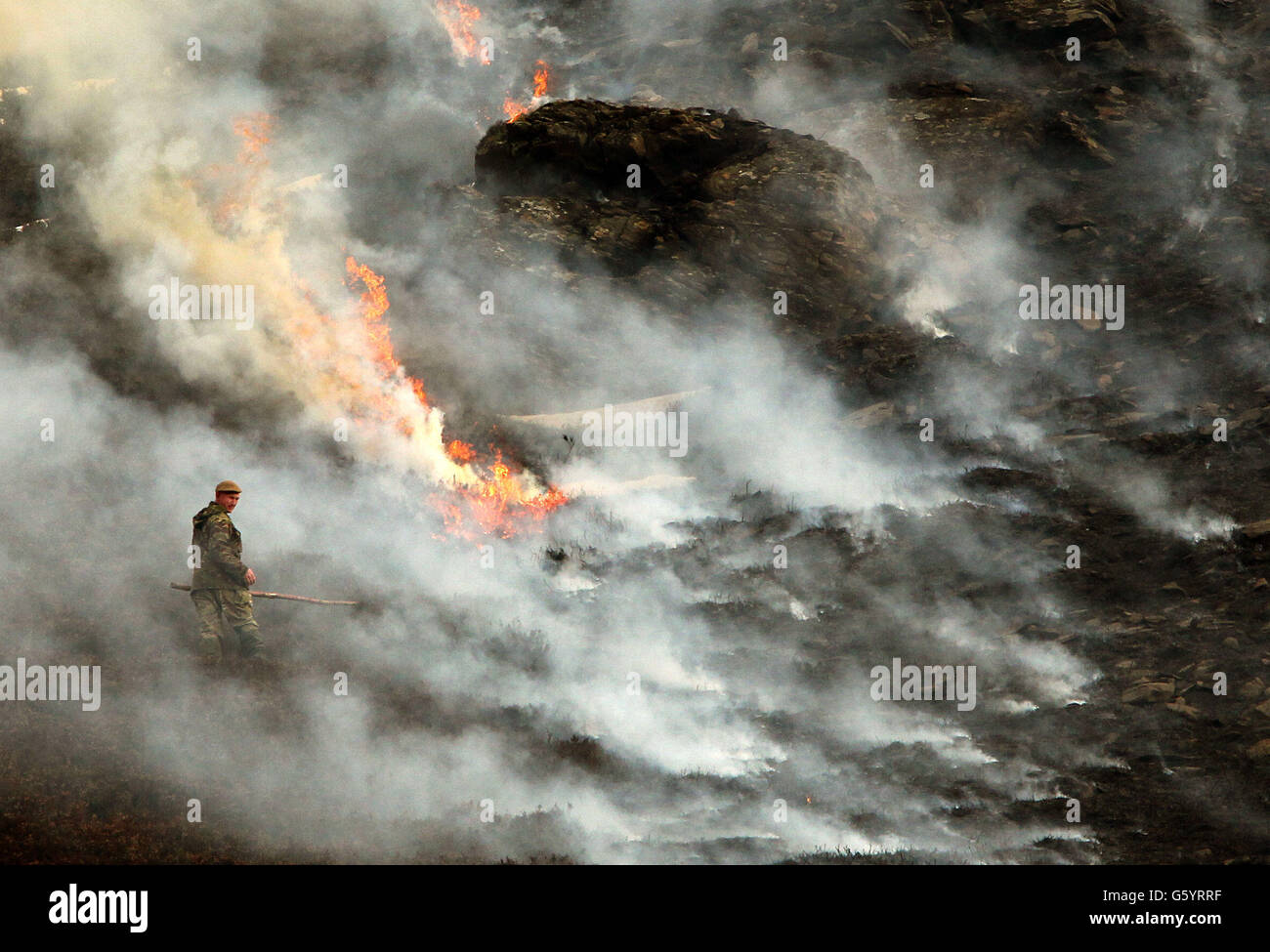 Ein Wildhüter kontrolliert die Flammen, da Heidekraut durch kontrolliertes Brennen oder "Abwischen", das jedes Jahr zwischen September und April auf dem Invercauld Estate bei Braemar stattfindet, jung und ordentlich gehalten wird. Stockfoto