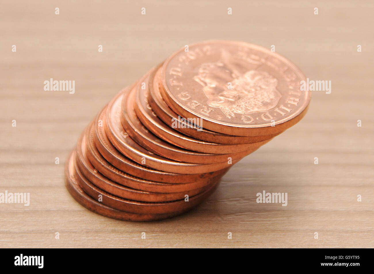 Geschäftsbestand. Ein Stapel britischer zwei-Pence-Münzen auf dem Hintergrund eines hölzernen Arbeitstisches Stockfoto