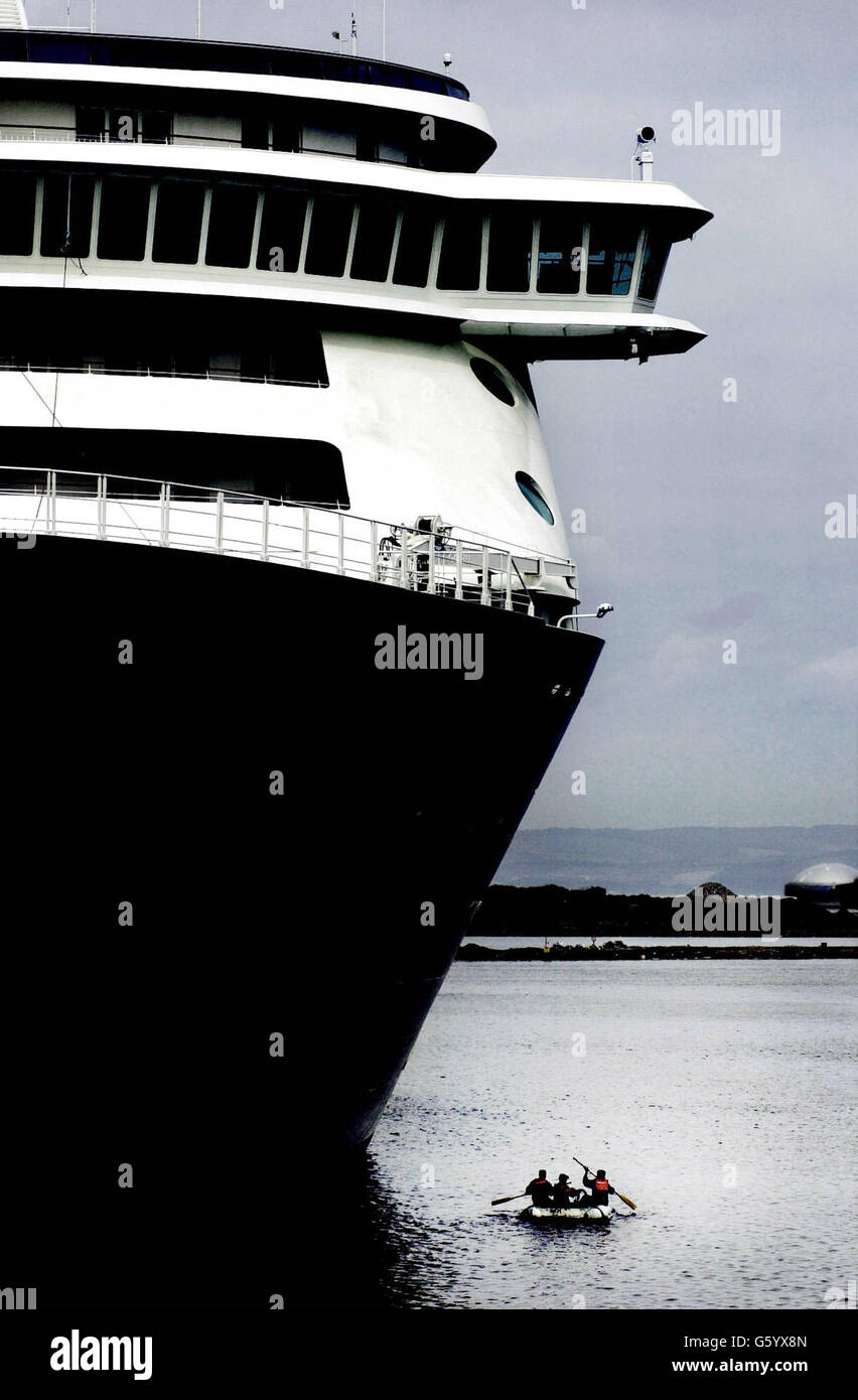 Drei Männer in einem Boot machen sich auf den Weg, um die Welt zu bereisen - ein 198 Millionen-Kreuzschiff. Die Welt kam in Leith, Edinburgh, mit 200 der reichsten Menschen der Welt an Bord. Drei der Besatzung umkreisten das Schiff in einem Ruderboot, nachdem es angedockt war. Stockfoto