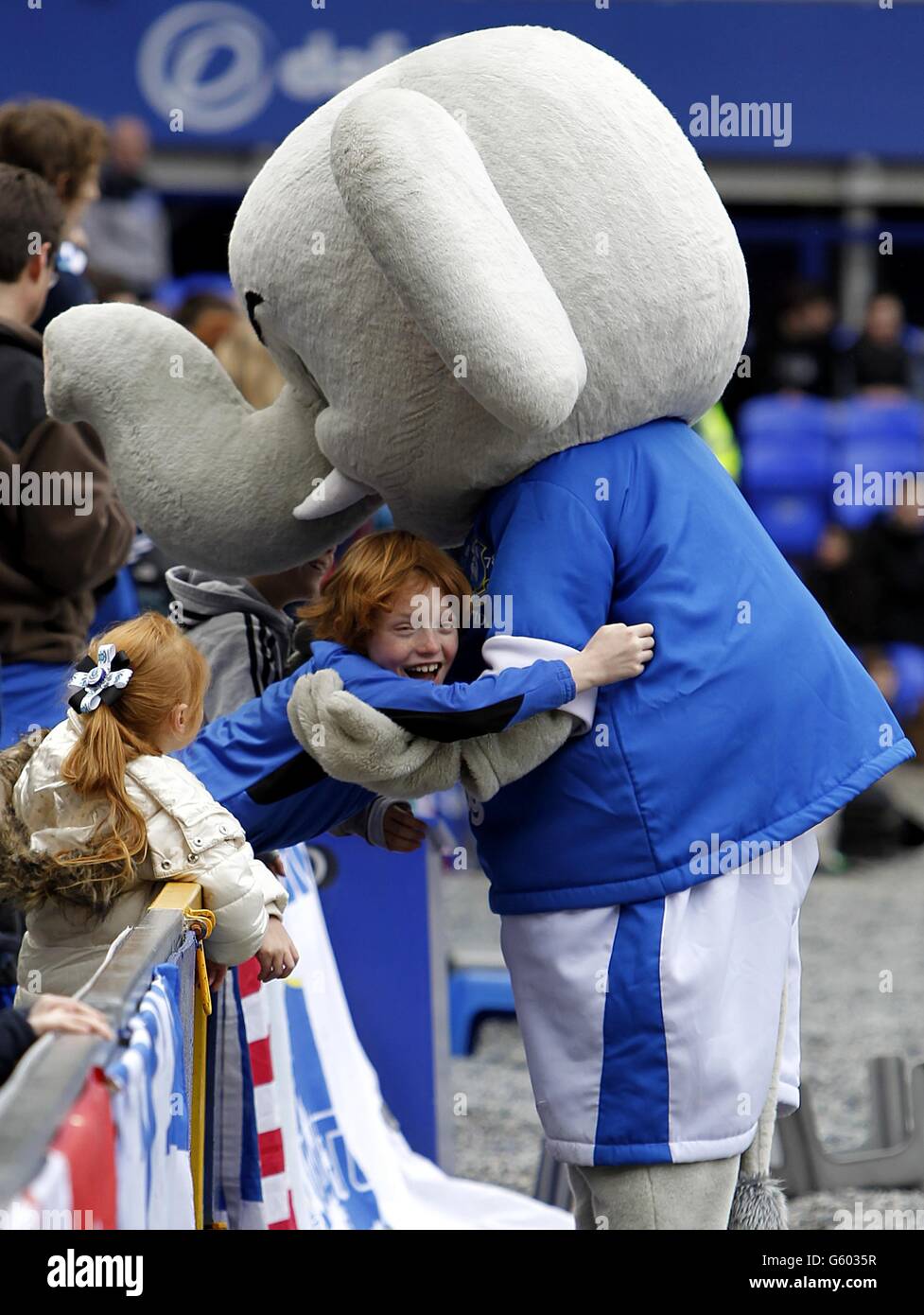 Fußball - Barclays Premier League - Everton gegen Manchester City - Goodison Park. Ein Everton-Fan hat eine Umarmung von dem Maskottchen Changy the Elephant Stockfoto