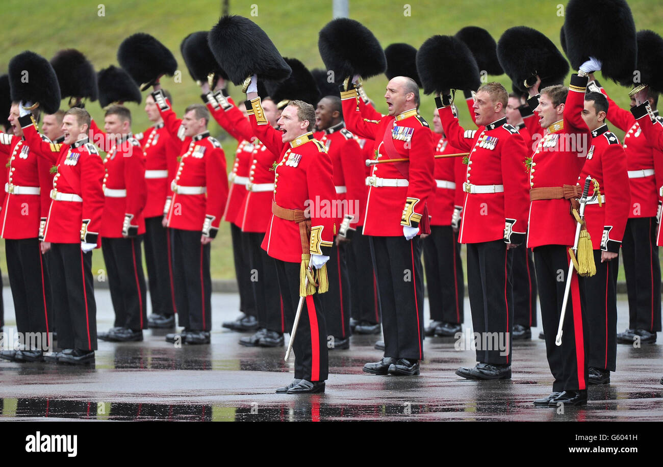 Mitglieder des 1. Bataillons Irish Guards erheben ihren Hut vor dem Besuch des Herzogs und der Herzogin von Cambridge beim 1. Bataillon Irish Guards, um an der St. Patrick's Day Parade in Mons Barracks, Aldershot teilzunehmen. Stockfoto