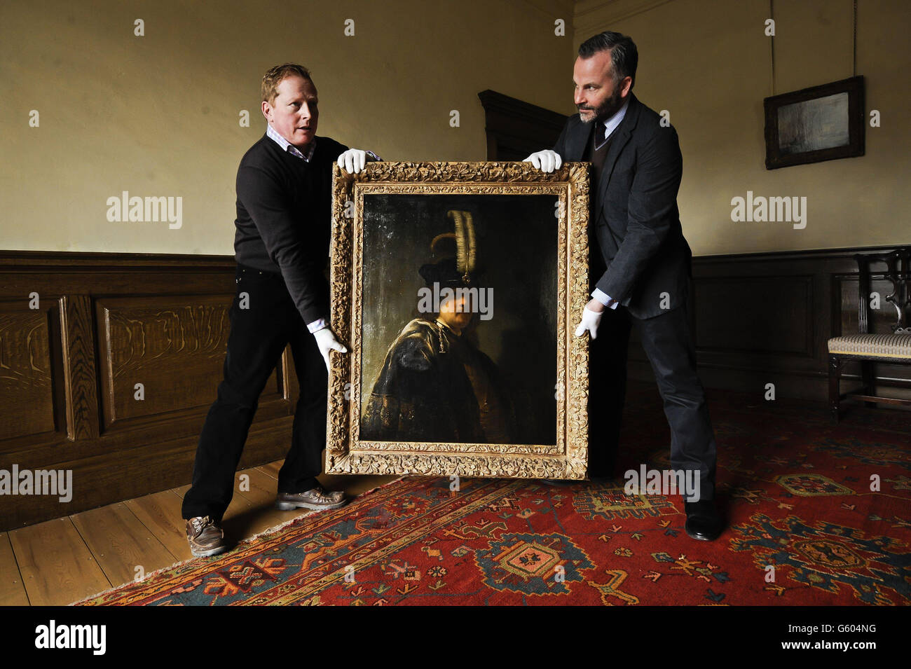 Immobilienmanager Jez McDermott, links, und Kurator für Bilder und Skulpturen in der Buckland Abbey David Taylor trägt vorsichtig ein kürzlich bestätigtes Selbstporträt von Rembrandt, das in der Devonshire Abbey entdeckt wurde. Stockfoto