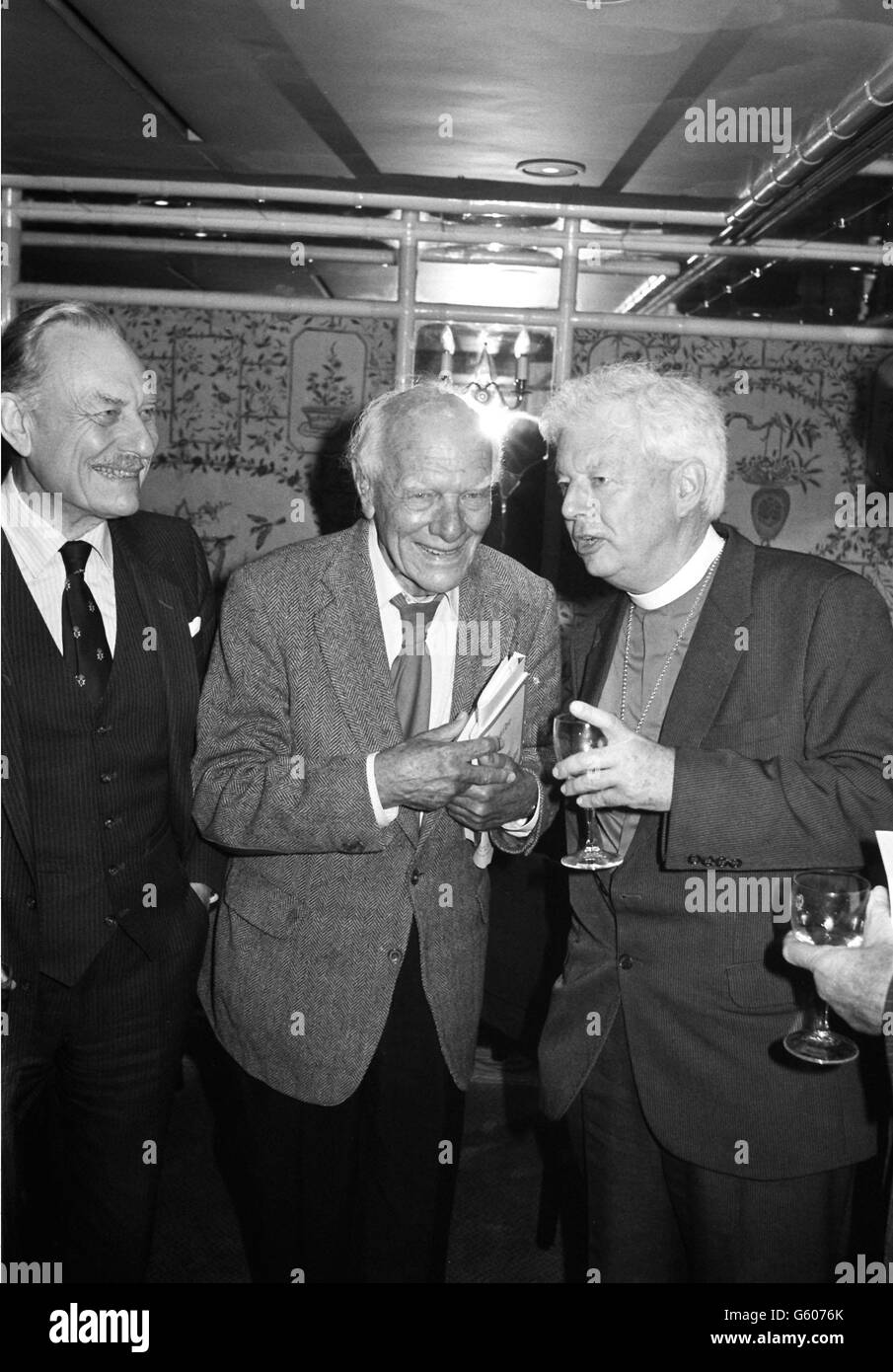 Malcolm Muggeridge (Mitte) teilt einen Witz mit dem Bischof von Durham bei einem Mittagessen zu seinen Ehren organisiert von Foyles Bookshop im Dorchester Hotel, um die Veröffentlichung von zwei neuen Büchern von ihm zu feiern. Auf der linken Seite ist der Vorsitzende Enoch Powell. Stockfoto