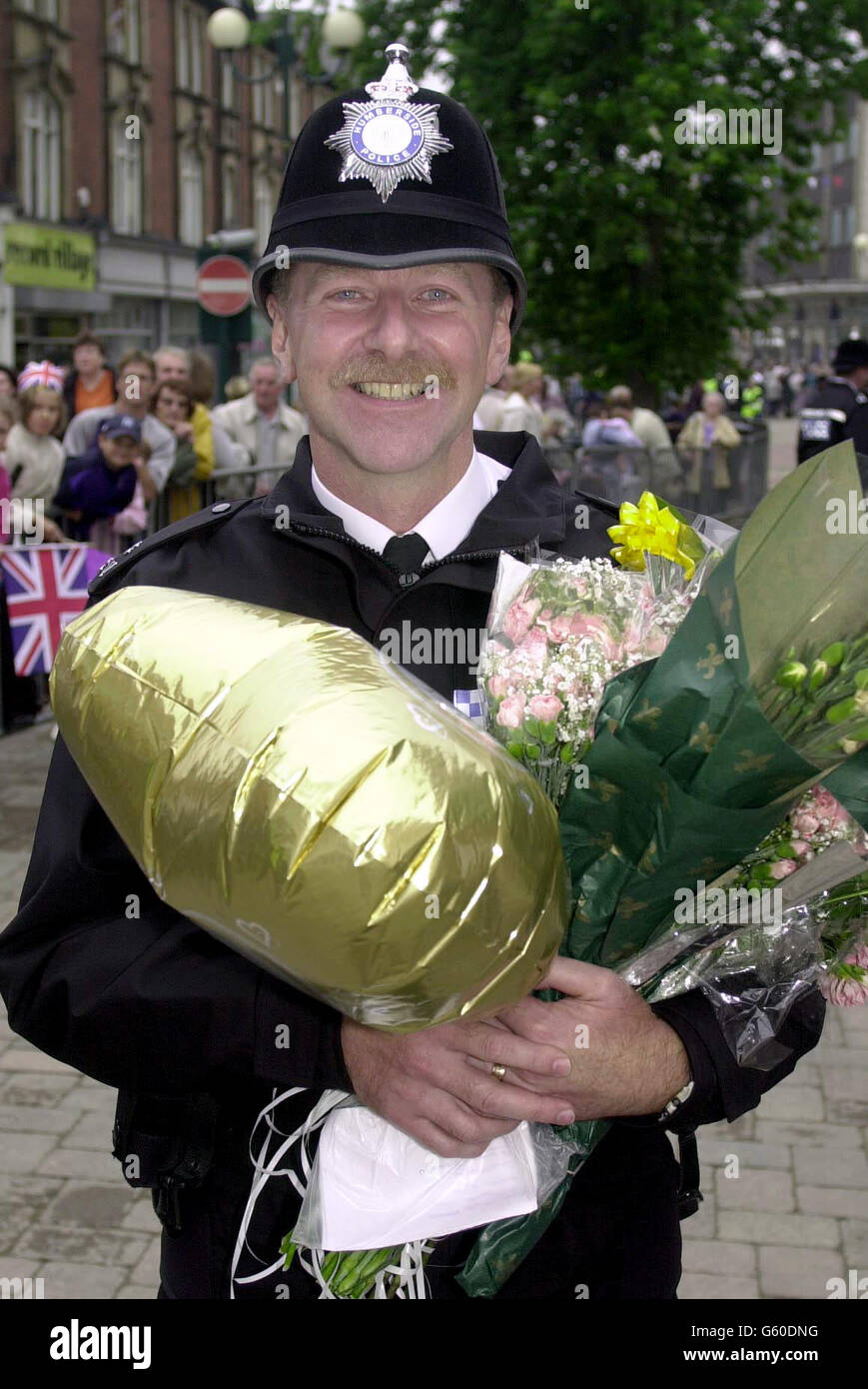 PC Graham Webb von der Polizei von Humberside bringt einige der großen Blumengeschenke mit, die der Königin während eines Spaziergangs auf dem Jubilee Walk in Scunthorpe, North Lincolnshire, während ihrer Tour zum Goldenen Jubiläum in der Gegend geschenkt wurden. * später werden die Königin und der Herzog von Edinurgh Nottingham besuchen, wo sie die Eistänzer Jayne Torvill und Christopher Dean treffen werden. Stockfoto