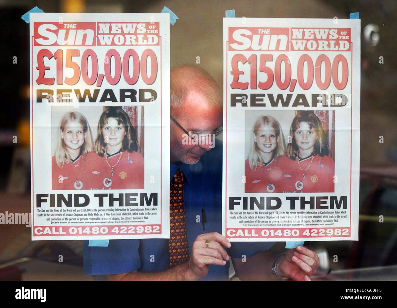 Ein Ladenbesitzer stellt in Soham, Cambridgeshire, "vermisste" Plakate auf, während die Jagd für Jessica Chapman und Holly Wells, beide 10, weiterging, die am Sonntagabend vermisst wurden und eine riesige Suche auslöste. * die Sonne und die Nachrichten der Welt haben eine gemeinsame Belohnung von 150,000 für jeden aufgelegt, der das Verschwinden der vermissten Mädchen löst. Express Newspapers, Eigentümer von Daily und Sunday Express und Daily Star, haben eine Million Belohnung für jeden angeboten, der Informationen gibt, die direkt zur Verhaftung und Verurteilung von jedem führen, der für das Verschwinden der beiden Kinder verantwortlich ist. Stockfoto