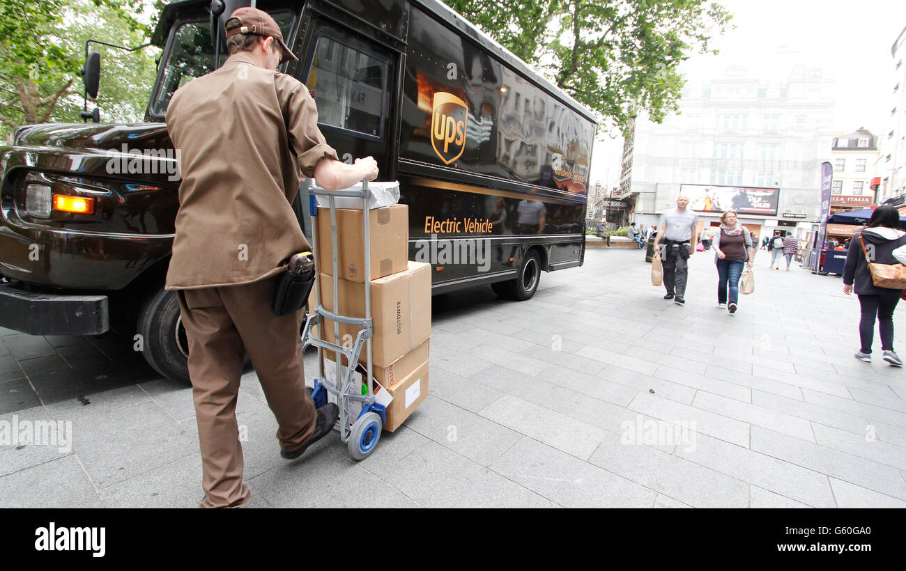 UPS United Parcel Service Logistikunternehmen, Lieferung, Elektro-Fahrzeug mit Fahrer und Pakete auf Wagen Stockfoto