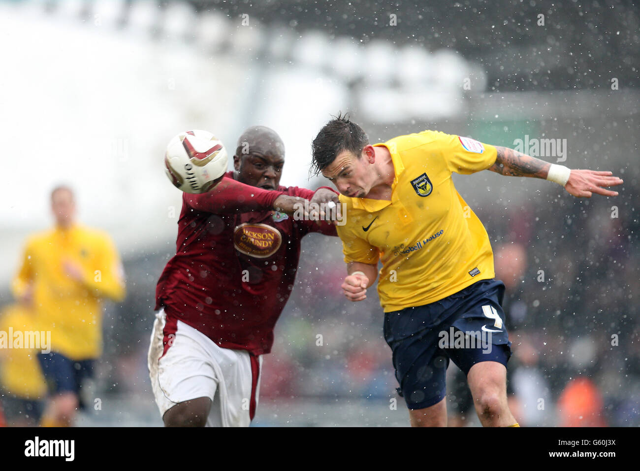 Adebayo Akinfenwa von Northampton Town und James Constable von Oxford United kämpfen während des Spiels npower Football League Two im Six Ways Stadium, Northampton, um den Ball. Stockfoto