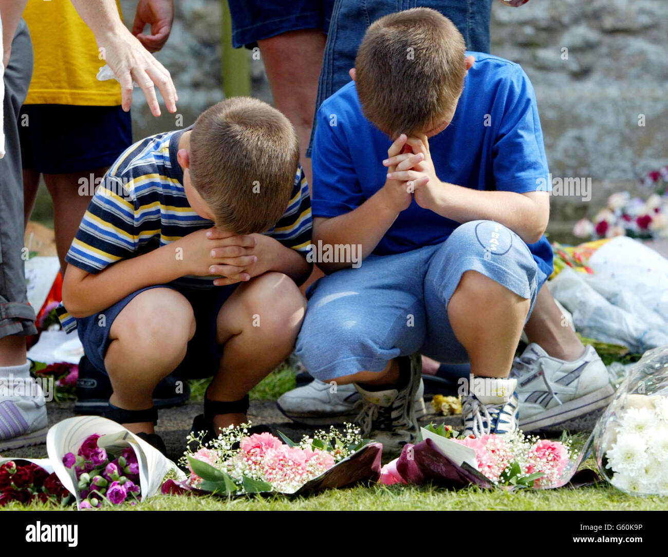 Zwei Jungen legen Blumen und beten in der St. Andrews Church, Soham, Cambs, für die ermordeten Schulmädchen Holly Wells & Jessica Chapman. Stockfoto