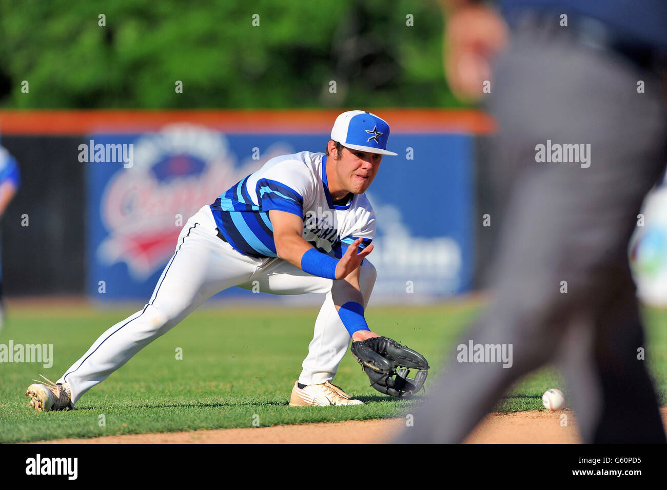 High School shortstop Fielding eine Kugel auf dem outfield Gras, bevor die erste Basis. USA. Stockfoto