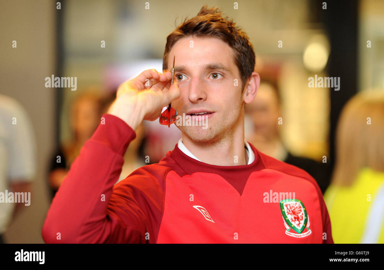 Wales und Liverpool Mittelfeldspieler Joe Allen nimmt an der Vauxhall 6 Dart Herausforderung während einer Fotozelle in Vauxhall - Ellesmere Port, Cheshire. Stockfoto