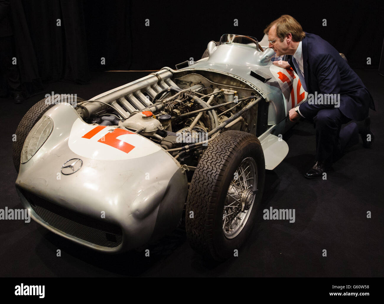 Der Vorsitzende des Bonhams-Auktionshauses Robert Brooks untersucht den 1954 2.5-Liter-Mercedes-Benz Formel-1-Grand-Prix-Einsitzer W196 von Juan Manuel Fangio bei einer Fotoserie in Bonhams im Zentrum von London. Stockfoto