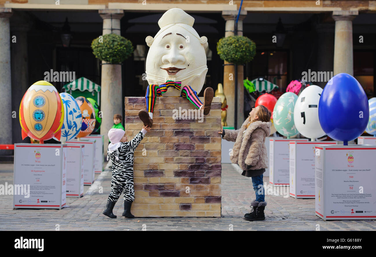 Chiara (links) und Mia Pegoraro schauen sich ein 4 Fuß großes Easter Egg im Humpty Dumpty-Stil in Covent Garden im Zentrum von London an, als Teil der Lindt Big Egg Hunt, die Kinderhilfe Action for Children unterstützt. Stockfoto