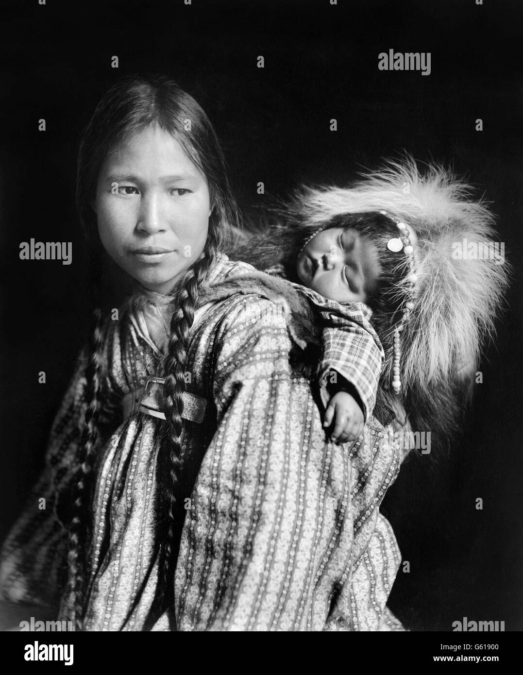Inuit-Frau, Tracht, mit einer Papoose auf dem Rücken im arktischen Alaska. Foto von H G Kaiser, c.1912 Stockfoto