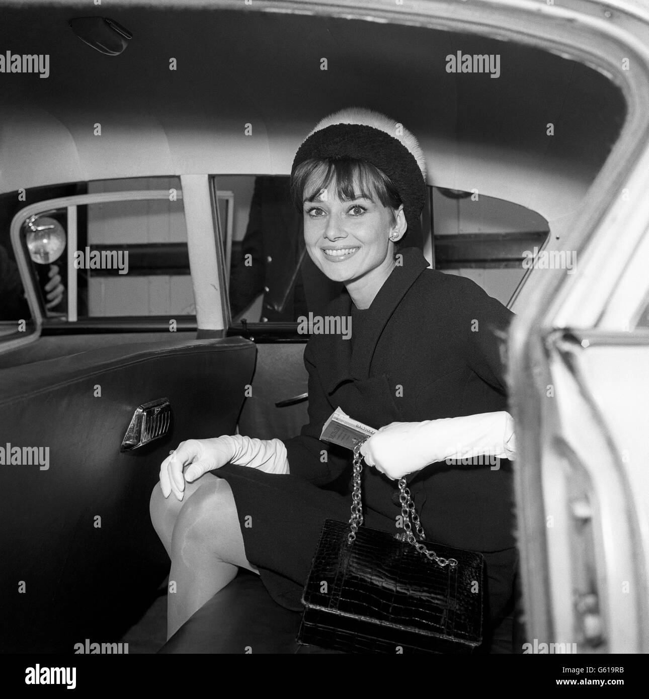 Audrey Hepburn in einem attraktiven, zweifarbigen, kontrastierenden Pelzhut, nach ihrem Flug von Rom nach Heathrow. Sie ist hier, um an der Europa-Premiere von „Breakfast at Tiffany's“ im Plaza Theatre teilzunehmen, in dem sie als „Holly Goligly“ spielt. Stockfoto