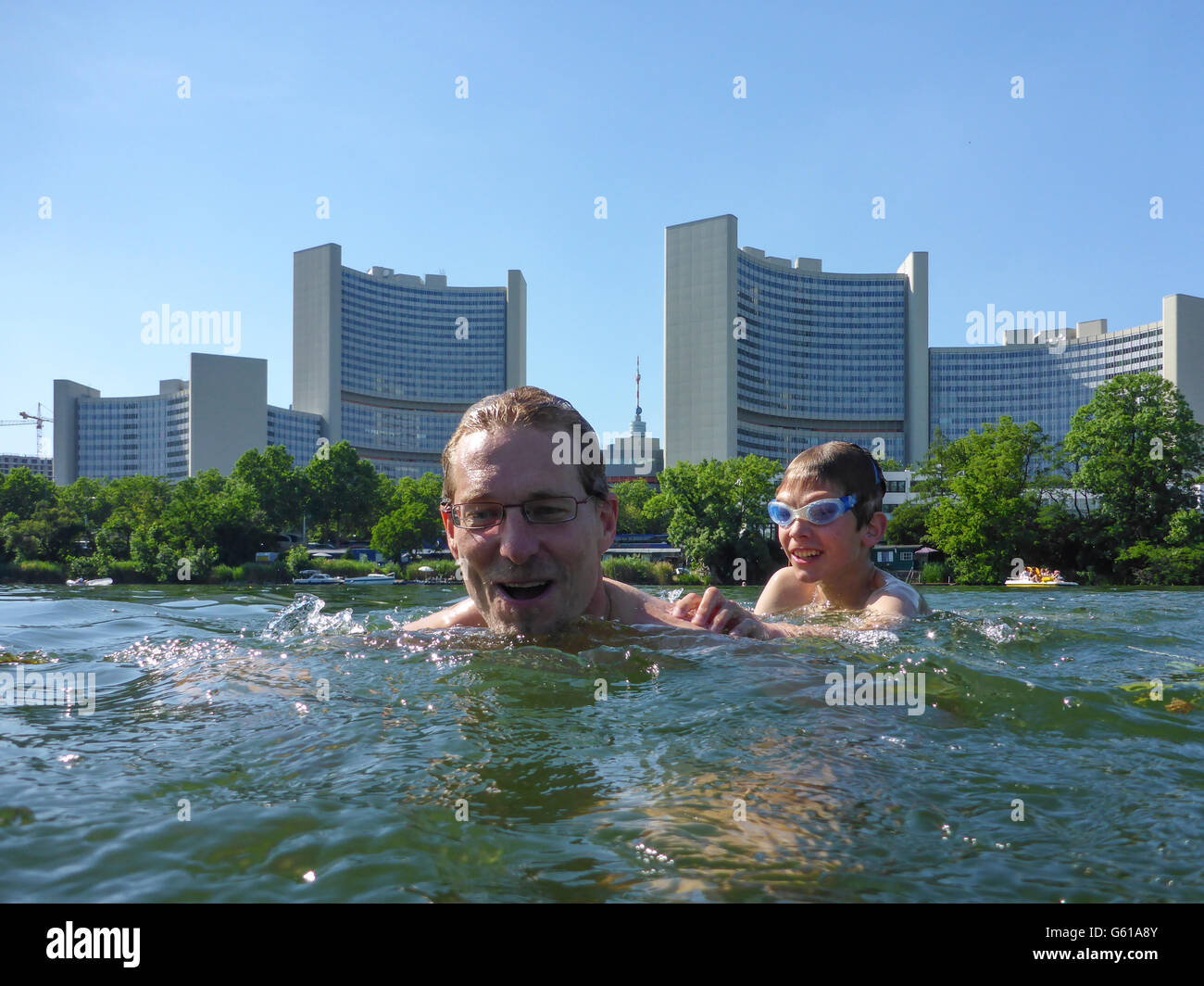 Vater und Kind schwimmen im See Kaiserwasser der alten Donau vor der UNO-City (Vienna International Center), Wien, Wien, Stockfoto