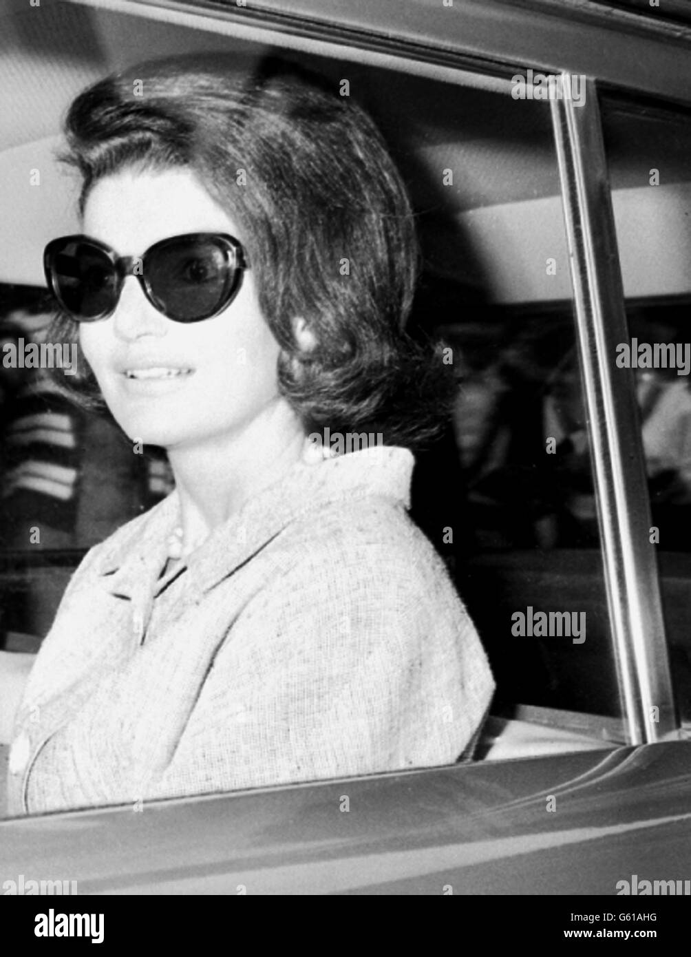 Ein Lächeln von Frau Jacqueline Kennedy, als sie mit Sonnenbrille mit dem Auto von ihrem Schwesterhaus, wo sie wohnt, abfährt. Stockfoto