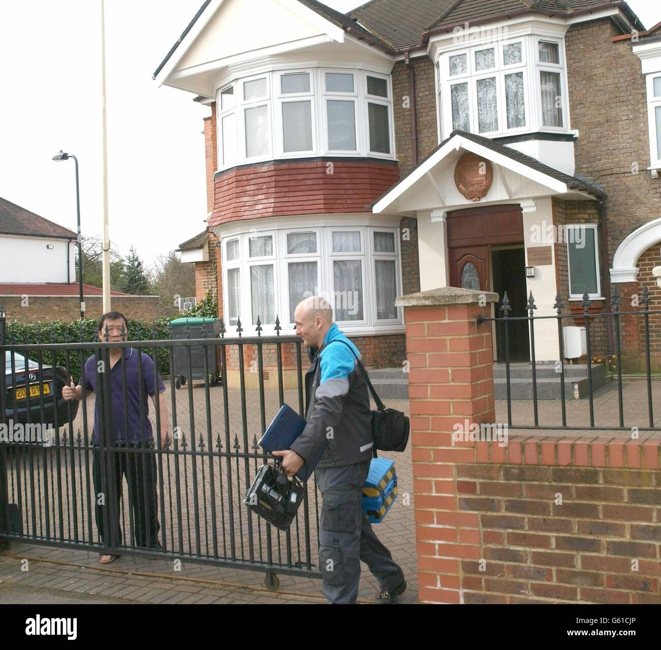 Ein Mitarbeiter der nordkoreanischen Botschaft lässt einen britischen Gastechniker (links) in Ealing, West-London, aus. Stockfoto