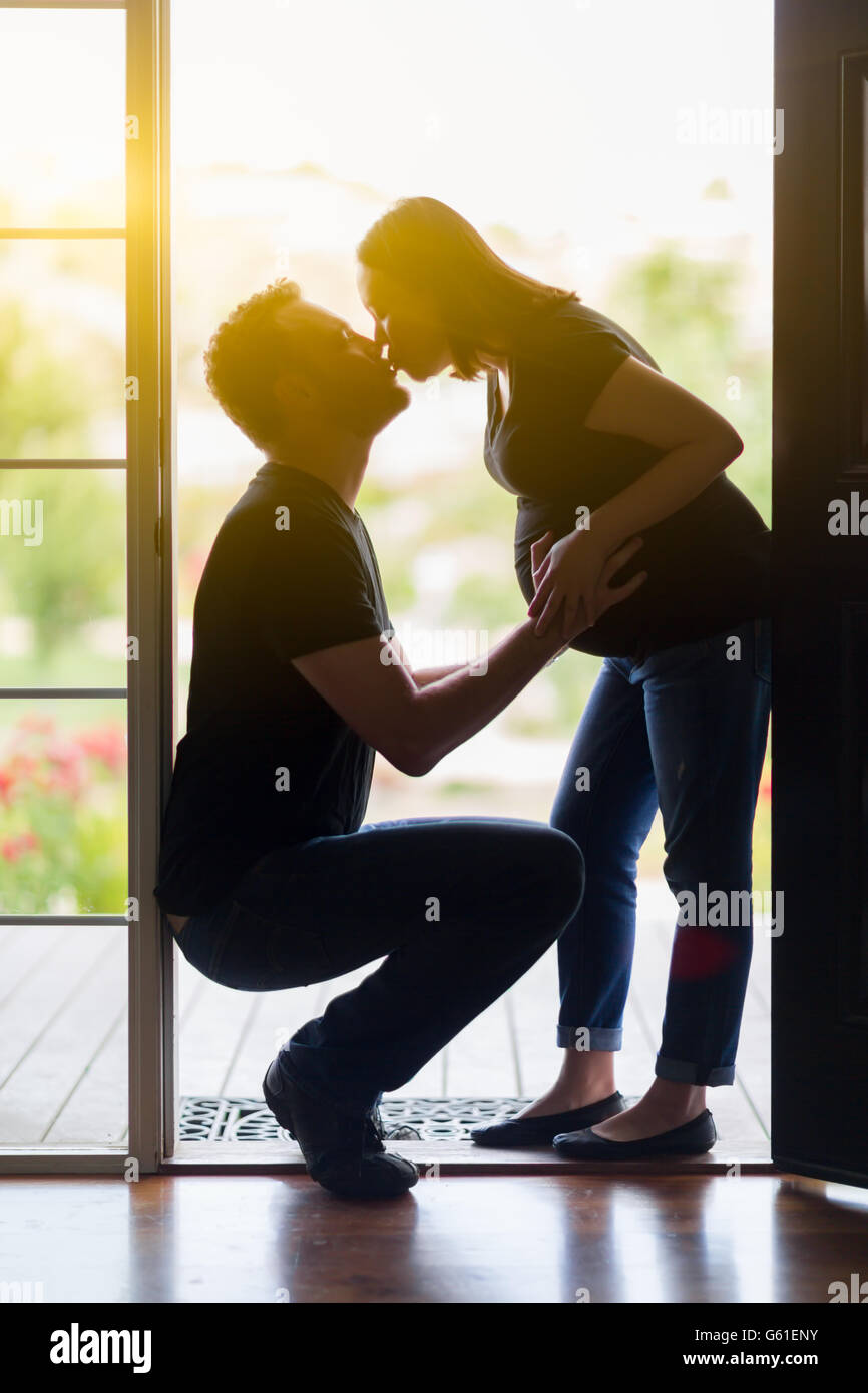 Gemischte Rassen schwanger Liebespaar in Tür küssen. Stockfoto