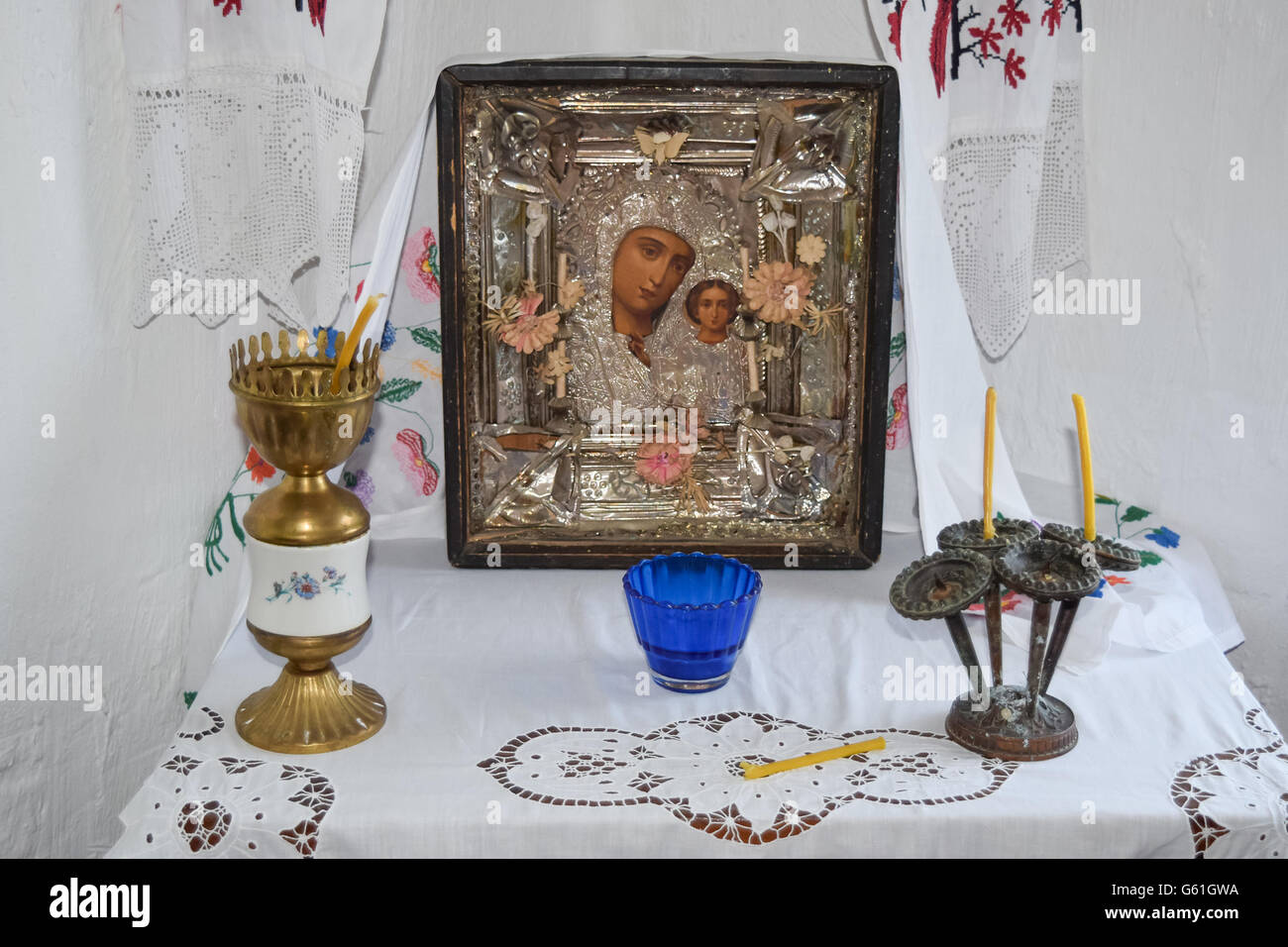 Gebetsbereich des Hauses. Muttergottes und Kerzen in Leuchtern auf dem Tisch. Stockfoto