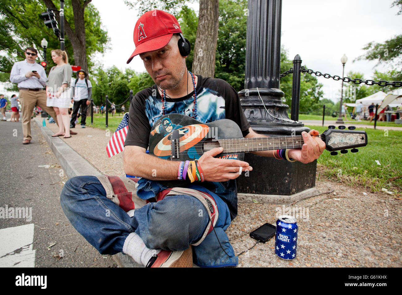 Mann sitzt auf dem Bürgersteig Gitarre - USA Stockfoto