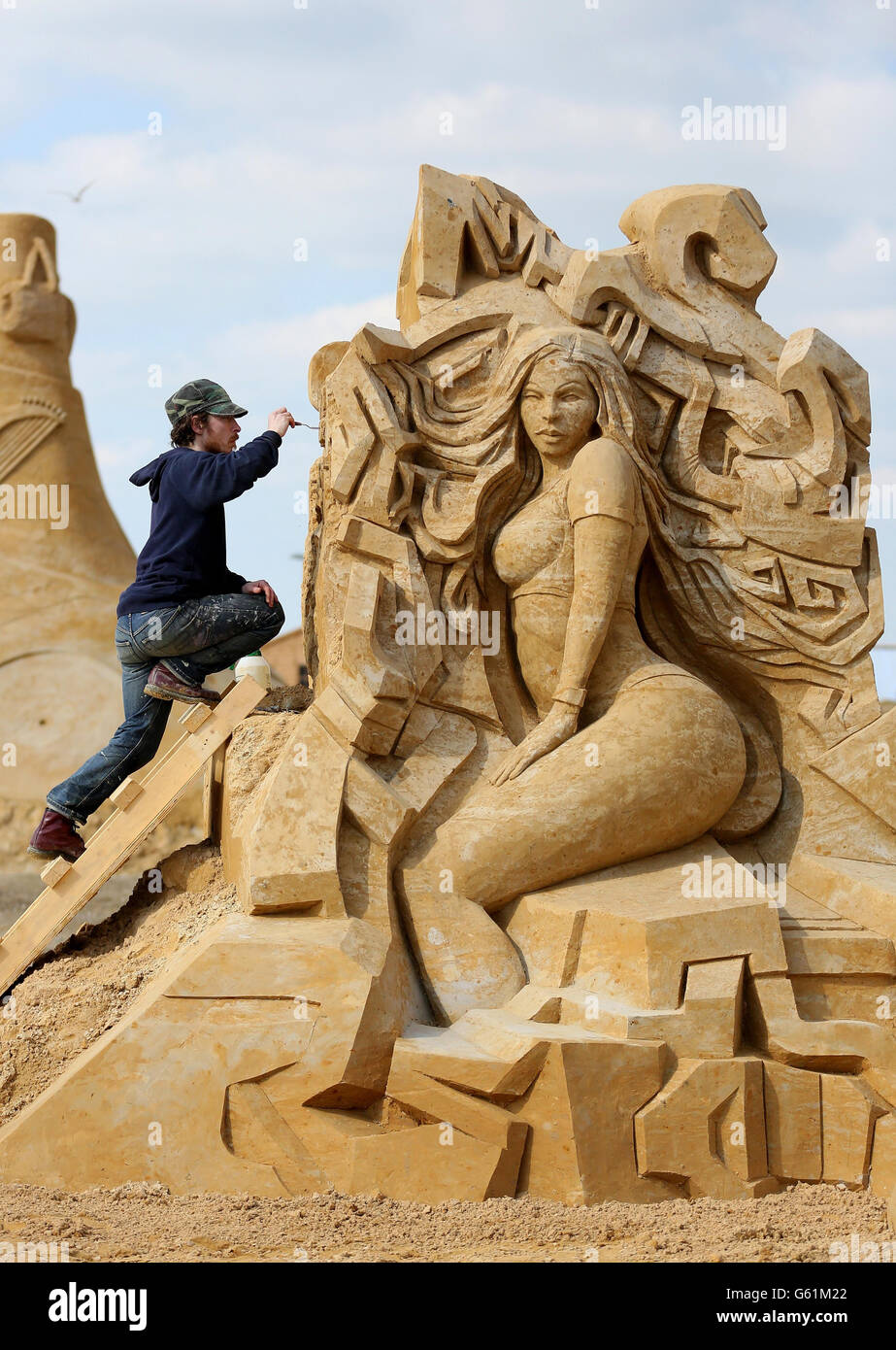 Der Bildhauer Barney Trattles bringt vor dem Start des „Sing-a-Song of Sculpture“-Festivals in Brighton den letzten Schliff zu seiner Musik-Sandskulptur. Stockfoto