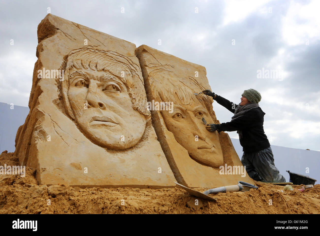 Die Bildhauerin Anique Kuizenga setzt ihre Sandskulptur von Liam Gallagher (links) und Damon Albarn vor dem Start des 'Sing-a-Song of Sculpture' Festivals in Brighton zum Abschluss. Stockfoto