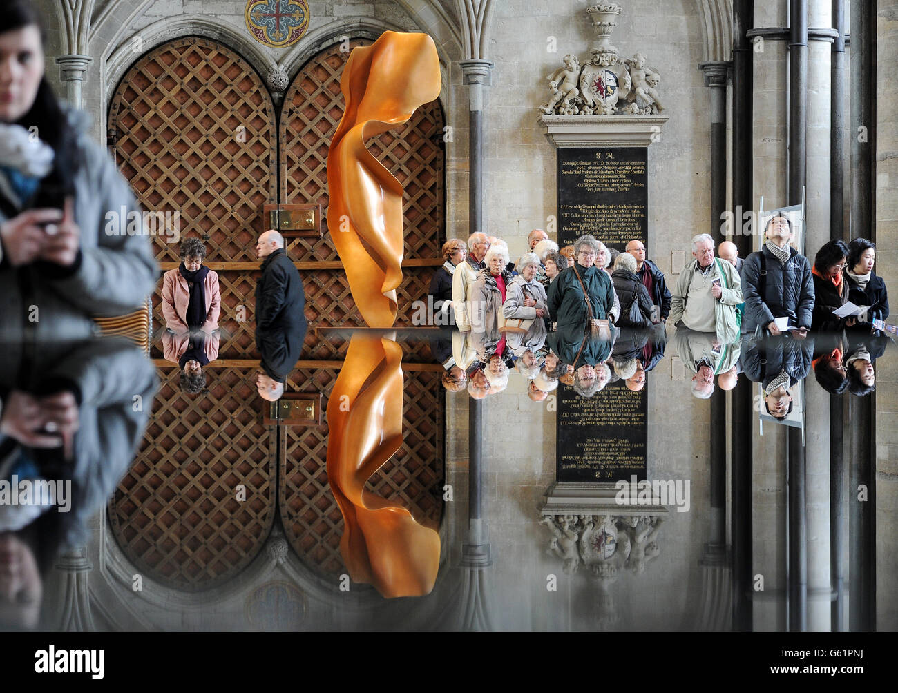 Eine Bronzeskulptur namens Flight der Künstlerin Helaine Blumenfeld und ihre Spiegelung im Taufbecken im Dom von Salisbury, der Teil einer Ausstellung ihrer im Dom installierten Arbeiten ist. Stockfoto