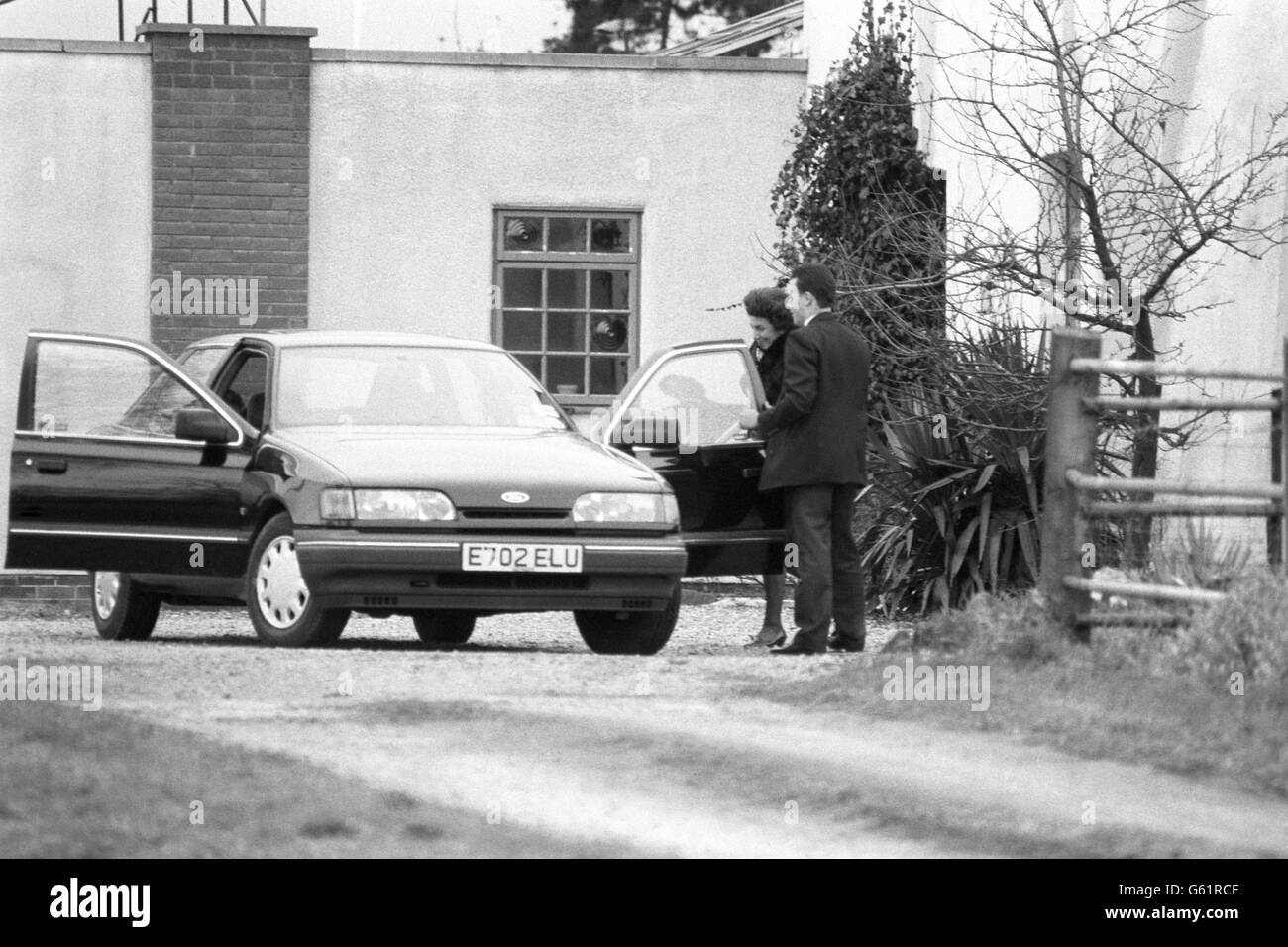 Ein Chauffeur hält die Tür offen, als Edwina Currie, Abgeordnete aus Derbyshire, vier Tage nach dem Rücktritt als Junior Health Minister in ihrem Haus in Findern bei Derby auf das Auto eilt. Stockfoto