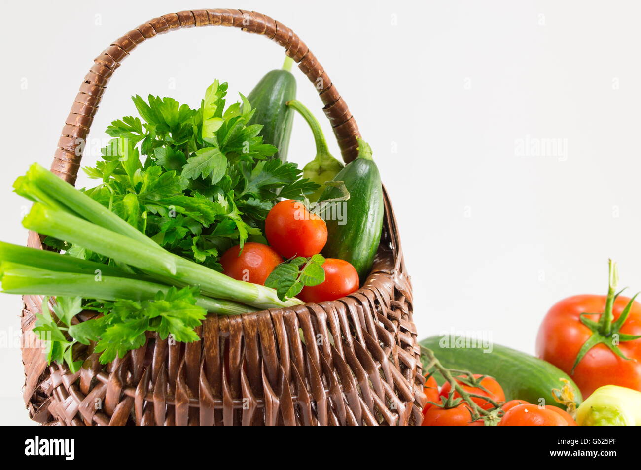 Frisches Gemüse in einem Korb vor weißem Hintergrund Stockfoto