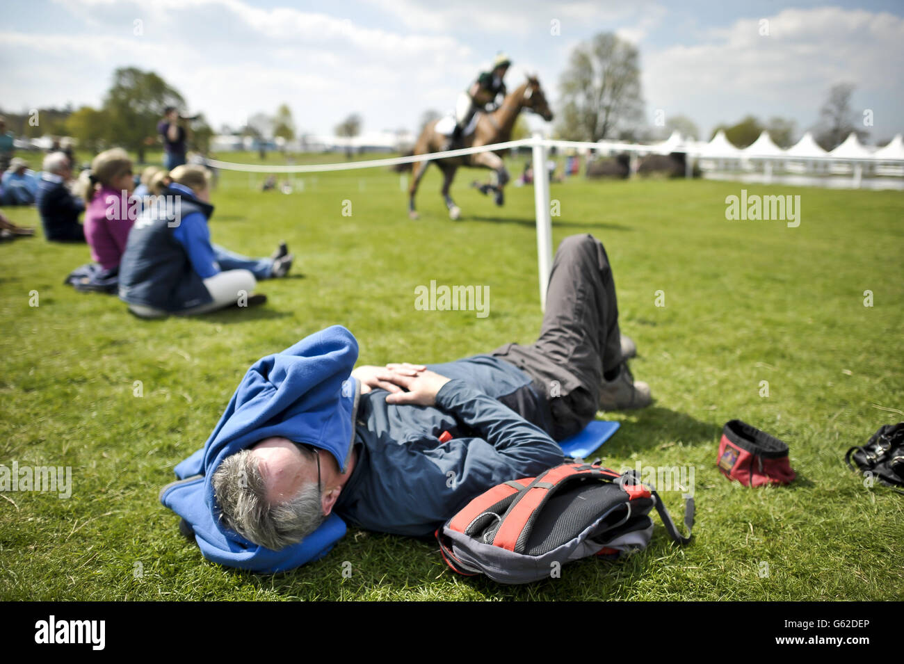 Ein Mann entspannt sich in der Sonne durch die Langlaufstrecke während des Tages eines der Badminton Horse Trials in Badminton, Gloucestershire. Stockfoto