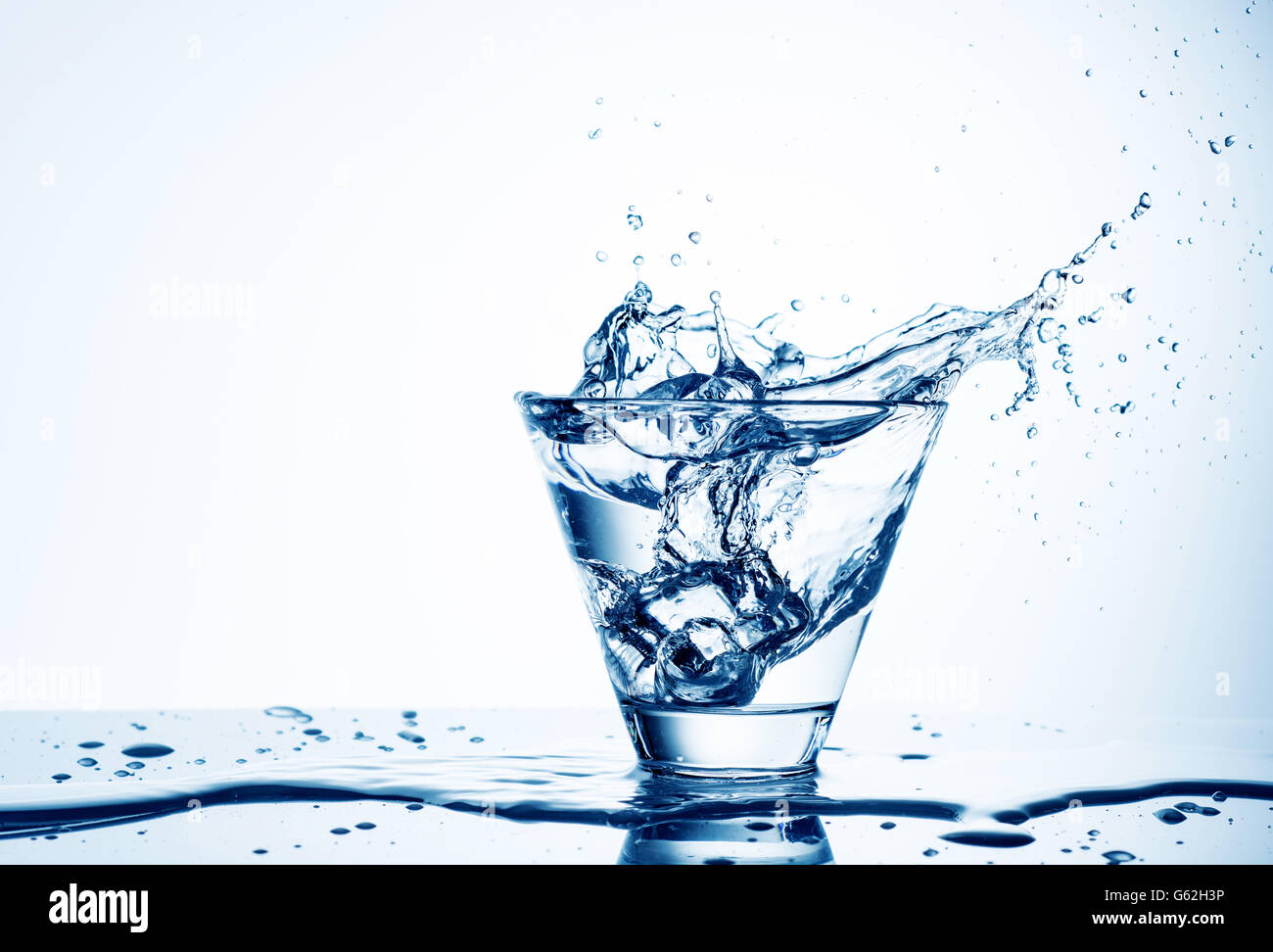 Eiswürfel, Spritzwasser in Glas Wasser, isoliert auf weiss Stockfoto