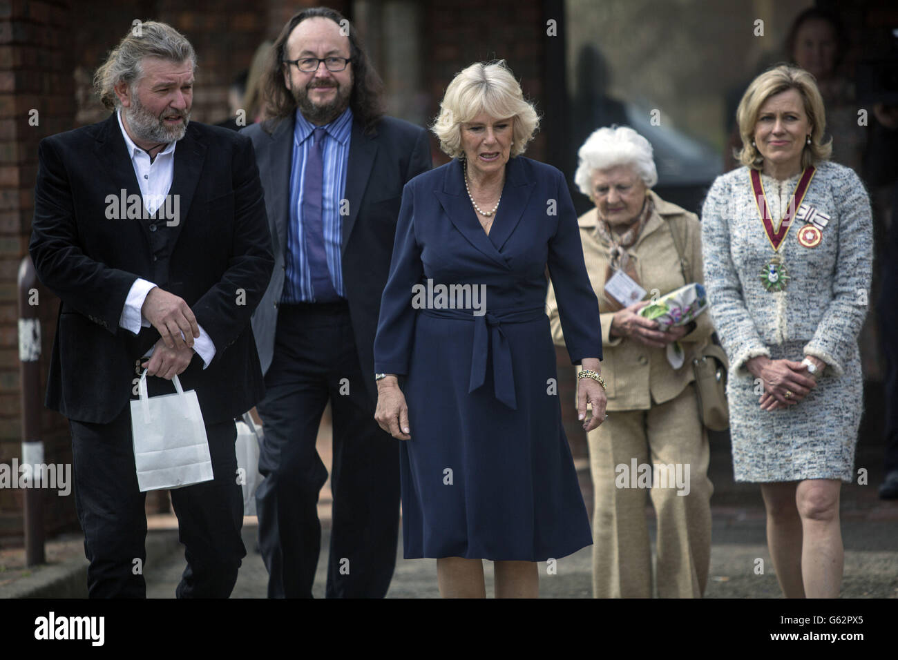 Herzogin von Cornwall geht mit Starköchen, die als Hairy Bikers', Simon King (links) und David Myers bekannt sind, spazieren und trifft Mitarbeiter während ihres Besuchs in einem Community Center, das vom Elmbridge Borough Council in Cobham, Surrey, betrieben wird, wo sie die Bedeutung des Service „Meals on Wheels“ des elmbridge council hervorhob. Stockfoto