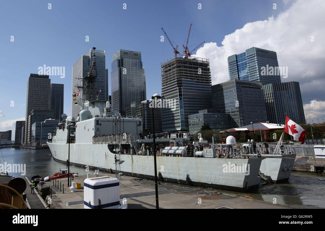 Die kanadische Seegrigate HMCS Iroquois wird entlang der Themse in das West India Dock in Canary Wharf im Osten Londons geschleppt. Stockfoto