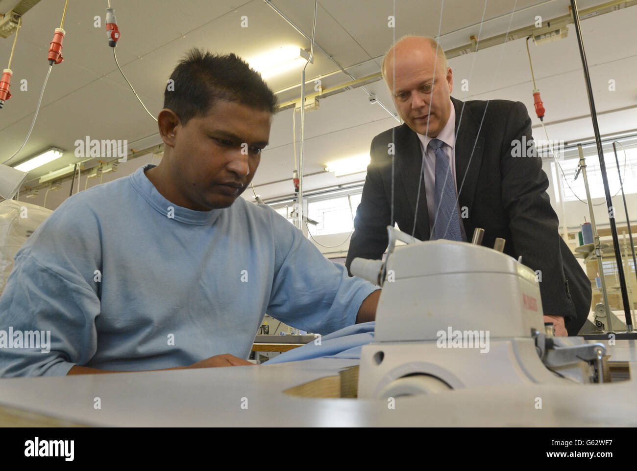 Justizminister Chris Grayling (rechts) spricht mit einem Häftling in einem Workshop während eines Besuchs im Pentonville Gefängnis mit dem Gefängnisminister Jeremy Wright (nicht abgebildet), bevor er das Ergebnis einer Überprüfung der Gefängnisvergünstigungen ankündigt. Stockfoto