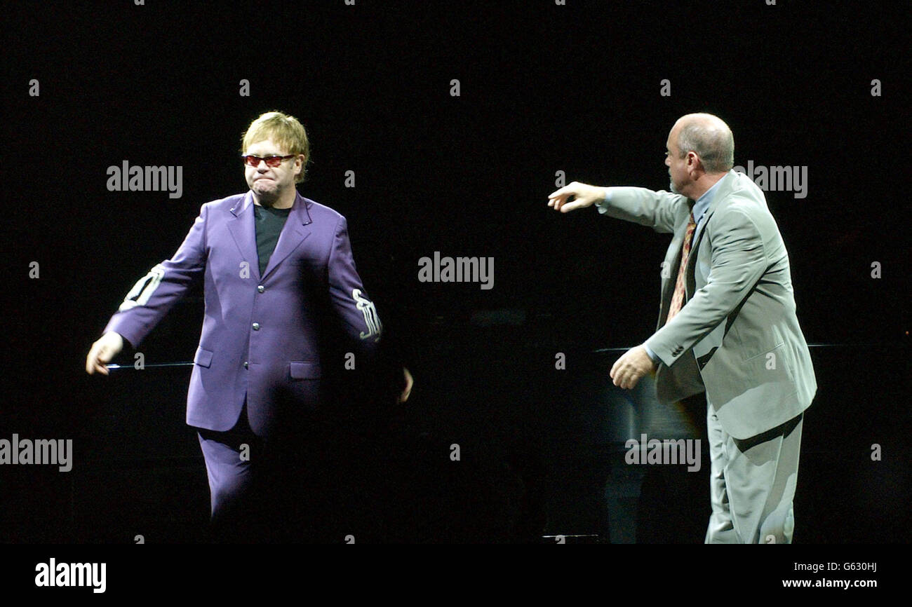 Sir Elton John (links) und der amerikanische Sänger Billy Joel umarmen sich vor dem Beginn ihres "Face to Face 2002"-Konzerts im Madison Square Garden in New York City, USA. Das Konzert wurde vom 18. März an neu geplant, weil Joel krank war. Stockfoto