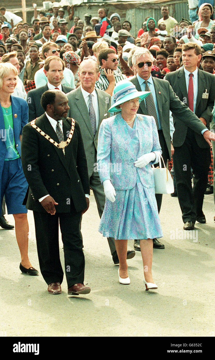 Die Königin und der Herzog von Edinburgh winken Wellwishers, während sie durch einen Teil der Gemeinde Khayelitsha gehen. Stockfoto