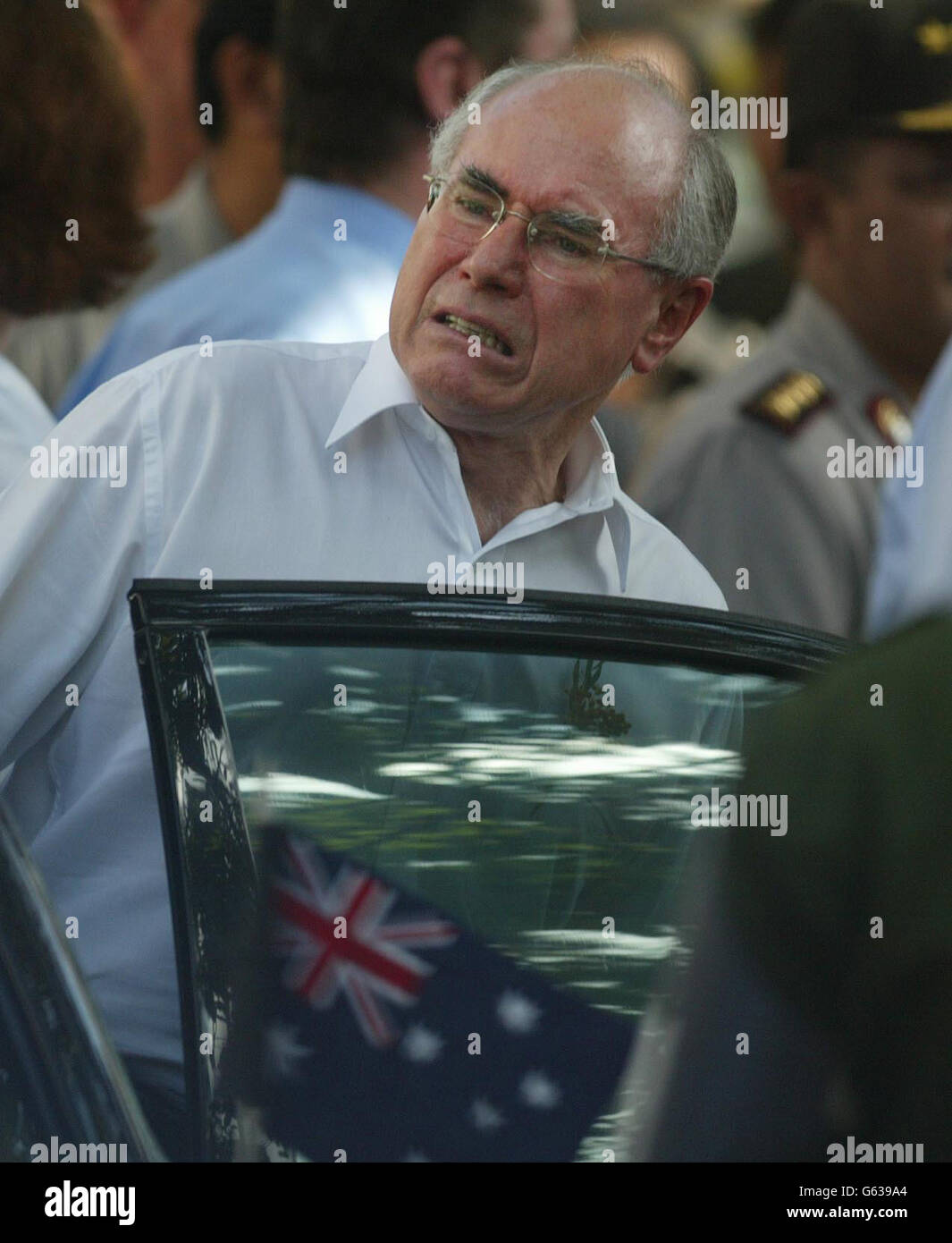 Der australische Premierminister John Howard verlässt die Szene in Kuta, Bali, des Autobombenanschlags auf den Sari Club in der Stadt. Während seines Besuchs auf der indonesischen Insel verteidigte er die Zeit, die es für die Freilassung von Leichen für die Rückführung brauchte. * und wiederholte seine Behauptung, dass Australien von keinem spezifischen Angriff auf die Ferieninsel wusste. Er sagte, dass die britische, die US-amerikanische und die neuseeländische Regierung sich alle darauf geeinigt hätten, dass es nicht genügend Beweise gebe, um Reisenden eine Warnung auszusenden. Stockfoto