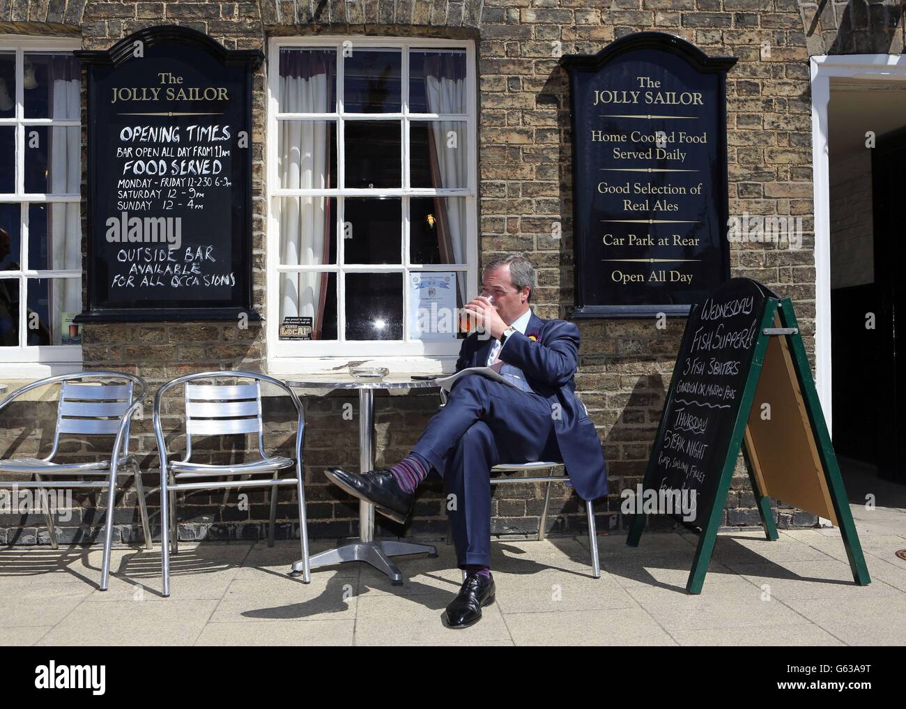 Der Leiter der UKIP Nigel Farage genießt eine kurze Pause auf dem lokalen Wahlkampfpfad während eines Besuchs in Ramsey in Cambridgeshire. Stockfoto