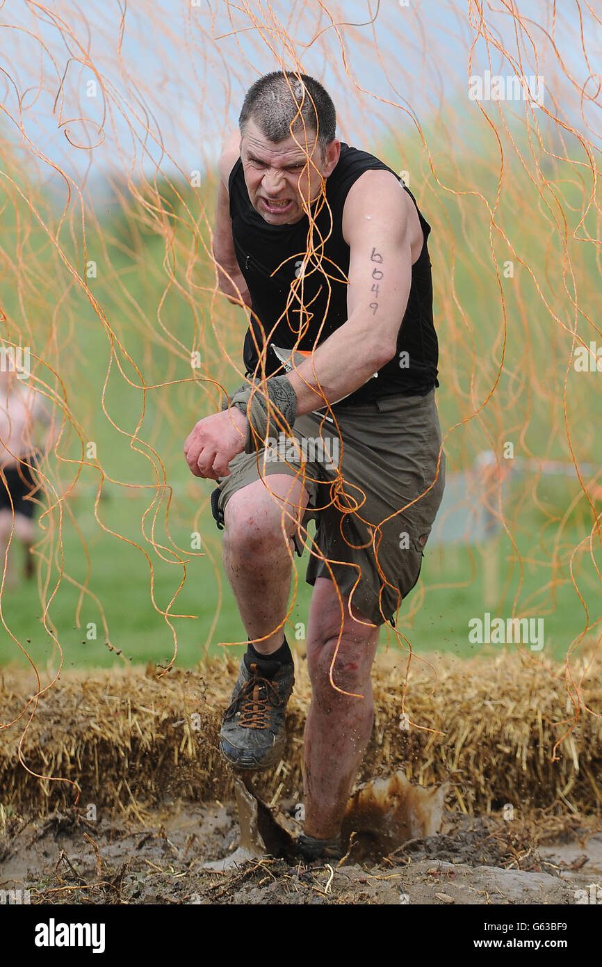 Die Teilnehmer nehmen an Tough Mudder im Boughton House, Kettering, Teil. Stockfoto