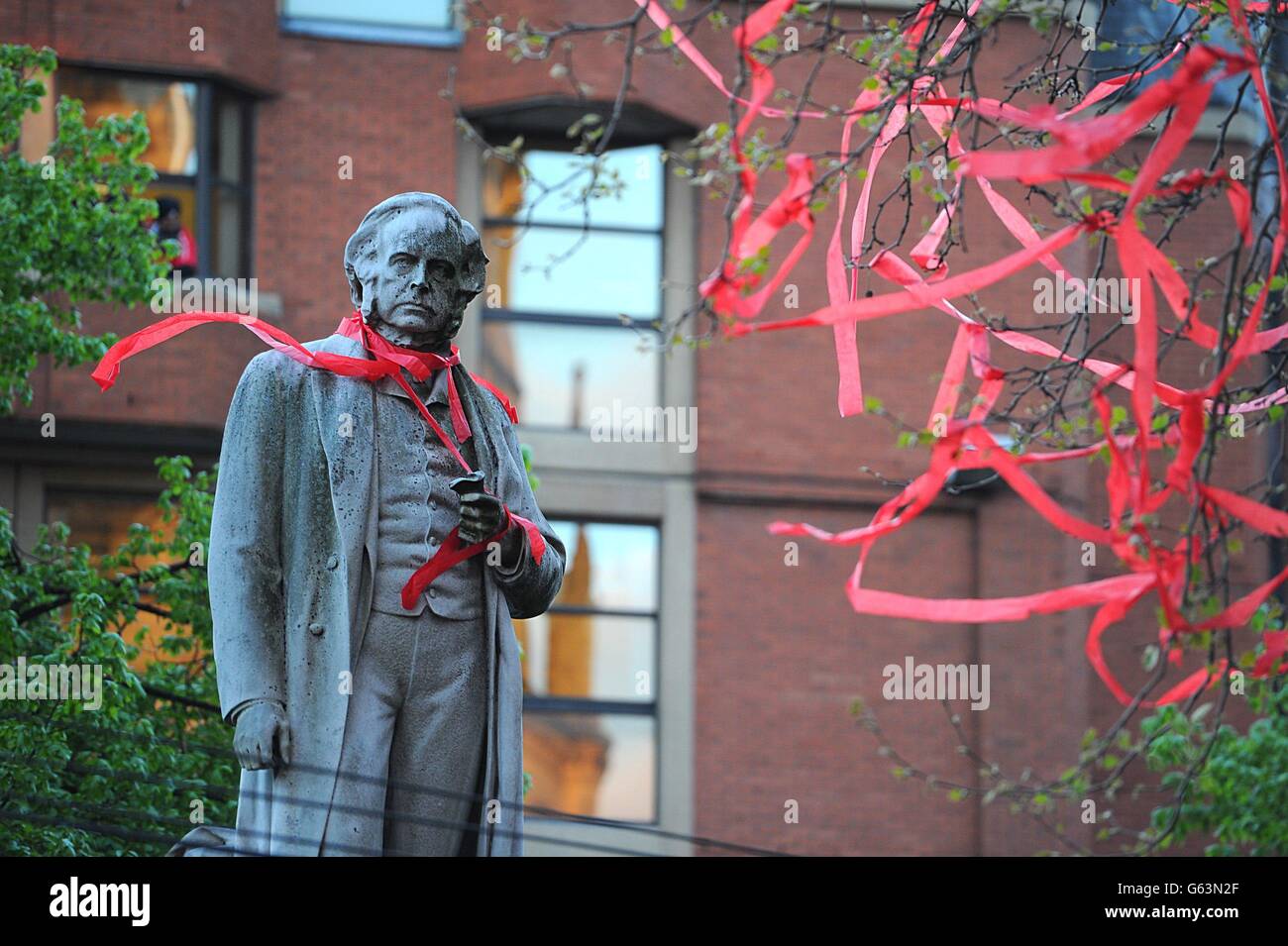 Die Statue von John Bright hat ein rotes Band um den Hals während der Barclays Premier League Gewinner Parade durch Manchester. Stockfoto