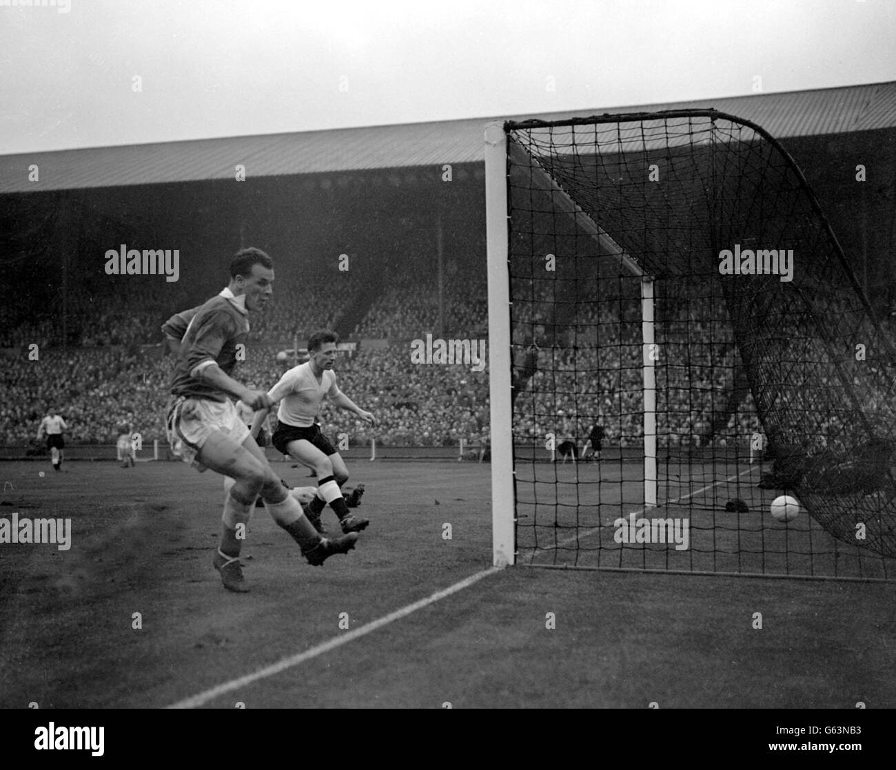 Wales' Mittelfeldspieler John Charles (links) schießt in ein leeres Netz, um das erste Tor seines Landes beim internationalen Fußballspiel gegen England im Empire Stadium Wembley, London, zu erschießen. Hilflos zuschauen, ist Englands linker Rücken, Roger Byrne. 08/02/04: Der ehemalige Stürmer John Charles aus Leeds, Juventus und Wales erholt sich nach einer Operation im Mailänder Krankenhaus San Carlo, um einen Teil seines rechten Fußes zu amputieren, wie ein Bericht vom 10. November 1954 berichtet. Der 72-Jährige unterzog sich einer Notfall-vaskulären Operation, nachdem er vor einem geplanten Auftritt als Experte im italienischen Fernsehen früher kollabiert hatte Stockfoto