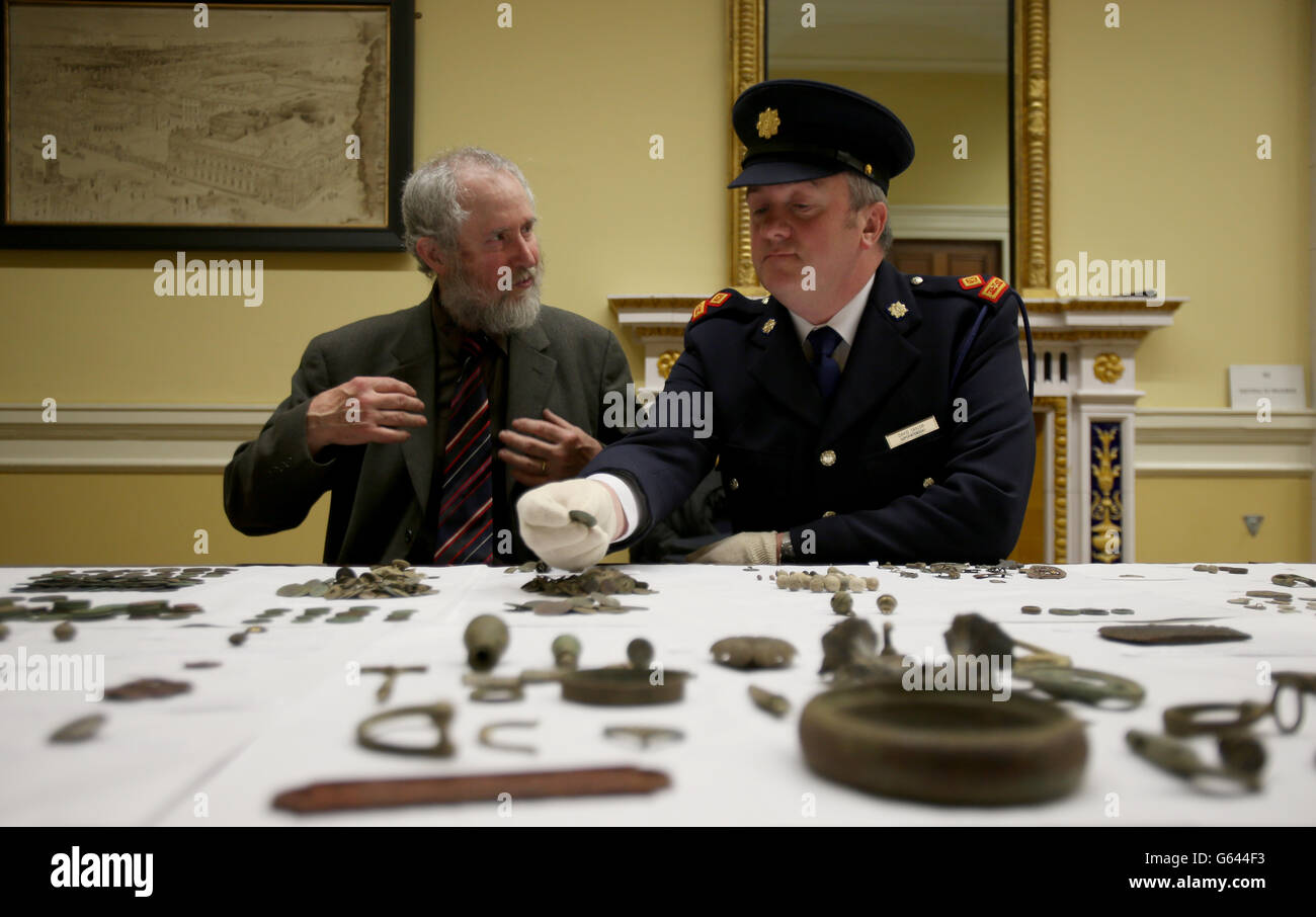 NED Kelly, Hüter von Antiquitäten am National Museum of Ireland (links) und Garda Superintendent David Taylor betrachten einige der 900 Artefakte, die illegal von einem Schatzsucher mit einem Metalldetektor in Irland geplündert wurden, Das den Medien im National Museum of Ireland in Dublin gezeigt wurde, nachdem sie bei einer Polizeioperation geborgen wurden. Stockfoto