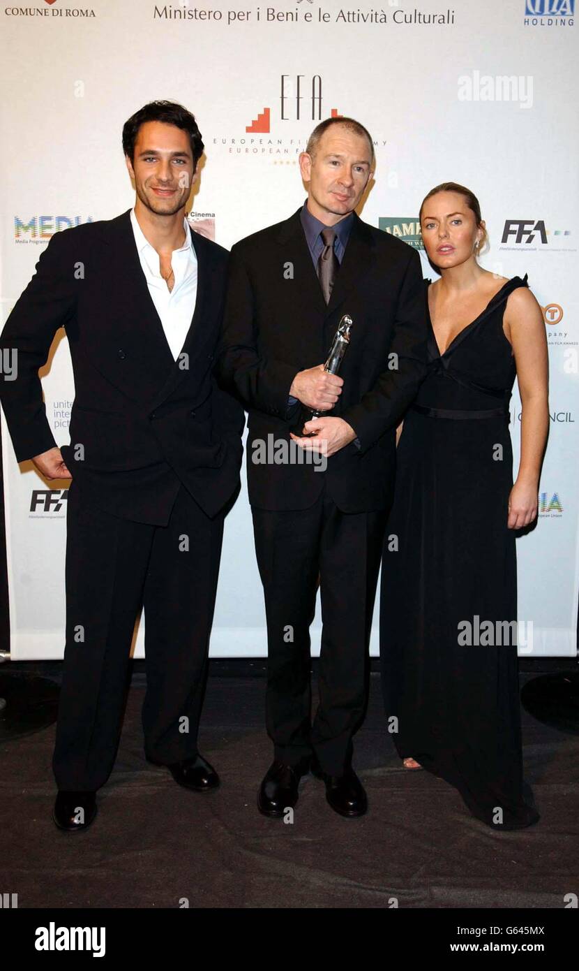 Pawel Edelman mit seinem European Cinematographer Award 2002, flankiert von Raoul Bova und Patsy Kensit, während der European Film Awards 2002, am Teatro dell'Opera di Roma, Rom, Italien. Stockfoto